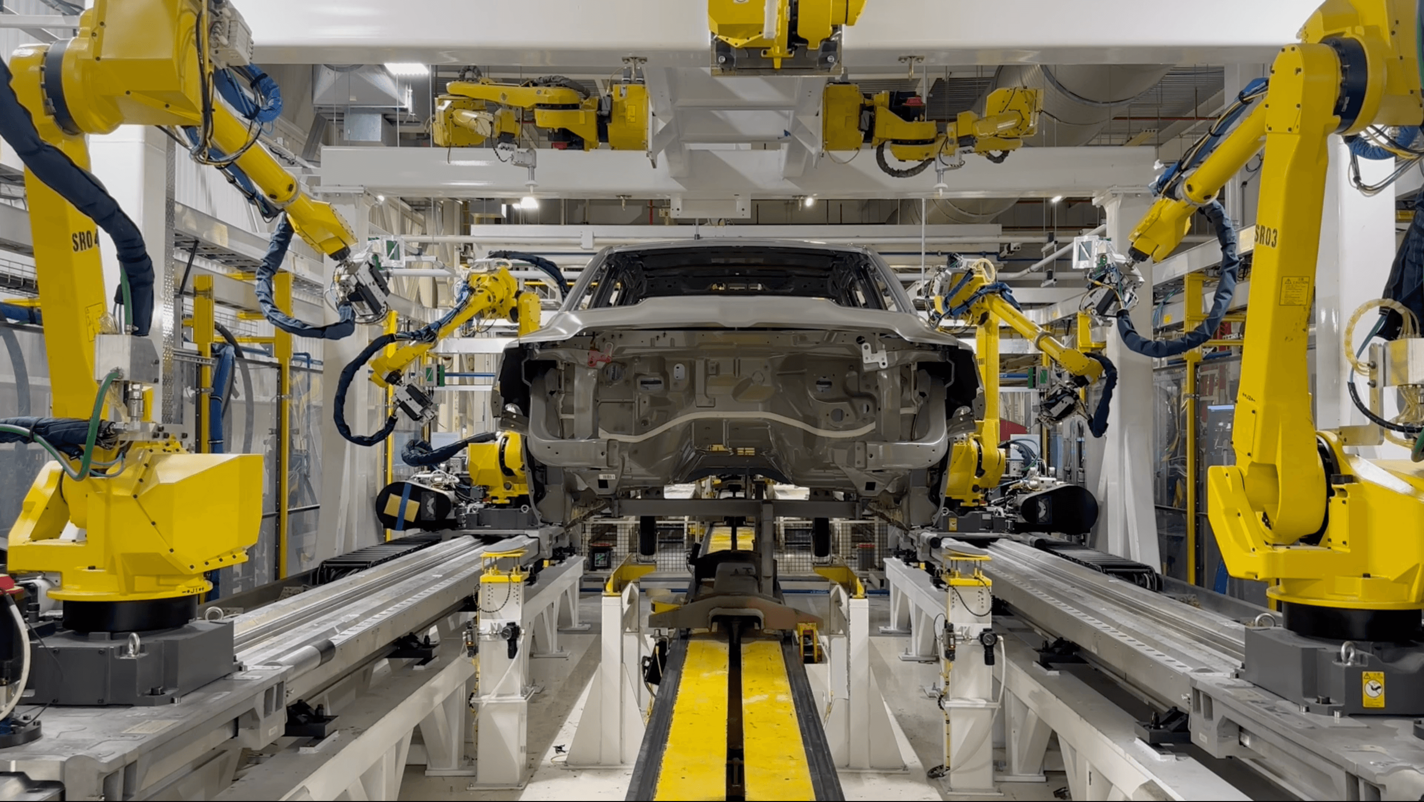 Robots Sealing a Car in Automation Industrial Setting